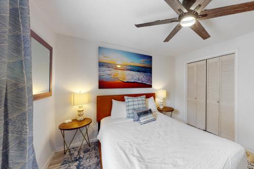 a bedroom with a bed with two tables and two lamps at Peaceful Hideaway - Upstairs Unit B in Galveston