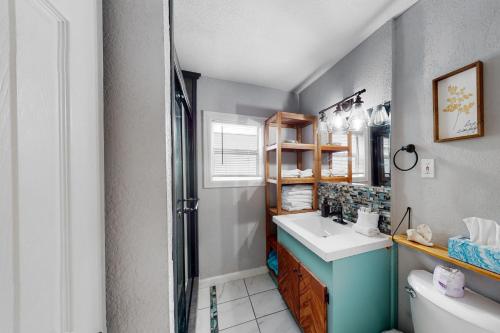 a bathroom with a sink and a toilet and a mirror at Peaceful Hideaway - Upstairs Unit B in Galveston