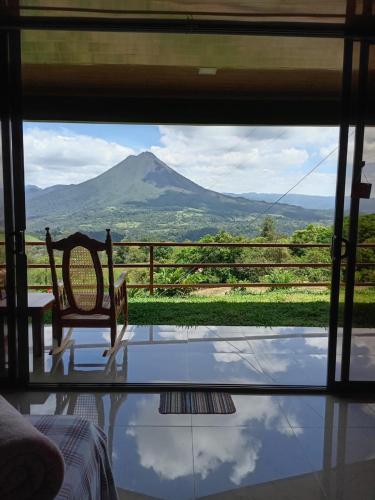 a room with a view of a mountain through a window at Encanto Arenal lodge in Fortuna