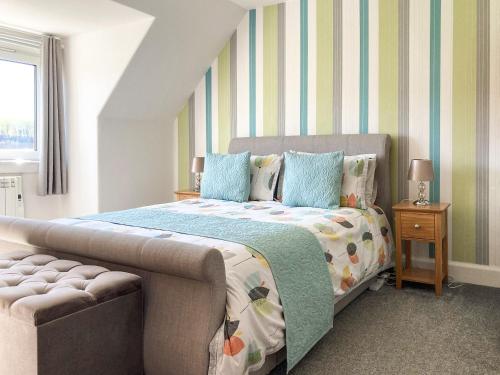 een slaapkamer met een bed en een bank erin bij Balnowlart Lodge in Ballantrae