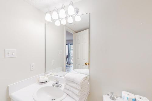 a white bathroom with a sink and a mirror at Bayview 15 in Orange Beach
