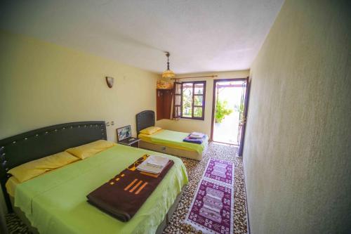 a bedroom with a bed and a window and a table at Troia Pension in Akçapınar