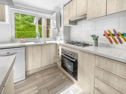 a kitchen with white cabinets and a stove top oven at *1era Línea 1er Piso* Jardín, Playa, Piscinas 6p in Puerto Velero