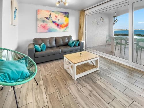 a living room with a couch and a table at *1era Línea 1er Piso* Jardín, Playa, Piscinas 6p in Puerto Velero