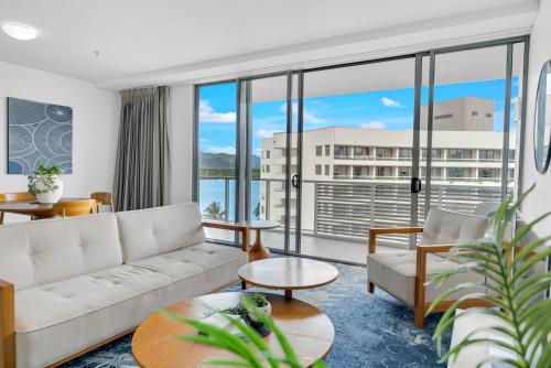 a living room with a couch and a large window at City Living at Harbour Lights in Cairns