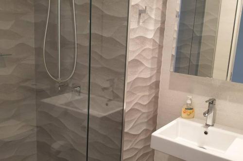 une douche avec une porte vitrée à côté d'un lavabo dans l'établissement 1011 Arena, à Newcastle
