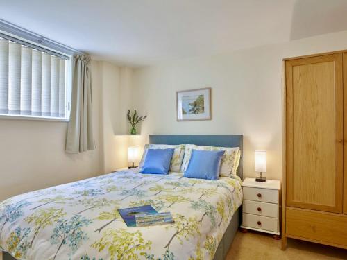 a bedroom with a bed with blue pillows at Polgew Apartment in Marazion