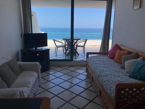 a living room with a couch and a view of the beach at Departamento Playa Paraiso in Concón
