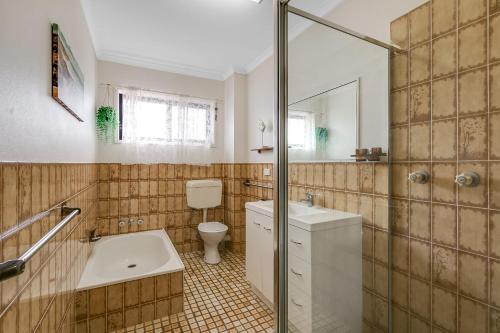 La salle de bains est pourvue d'un lavabo, de toilettes et d'un miroir. dans l'établissement Unit 7 18 Endeavour Parade, à Tweed Heads