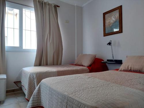 a bedroom with two beds and a window at Depto Centro de Carlos Paz in Villa Carlos Paz