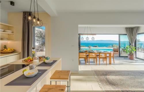 a kitchen and dining room with a view of the ocean at Nice Home In Ravni With Sauna in Ravni