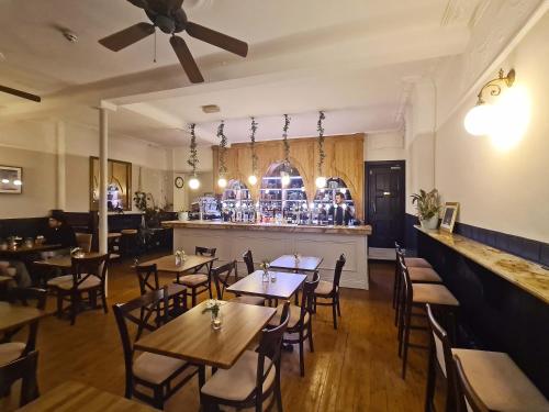 a restaurant with wooden tables and chairs and a bar at The Greenwich Pensioner Guesthouse in London