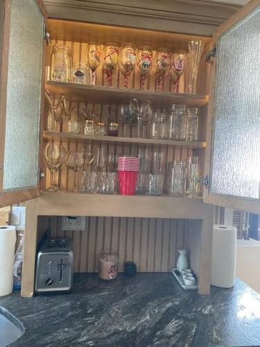 a shelf with many glasses on it in a kitchen at A little place in the Sun in Milford