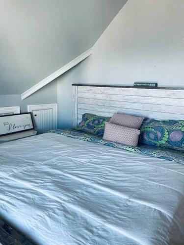 a bedroom with a large blue bed with pillows at A little place in the Sun in Milford