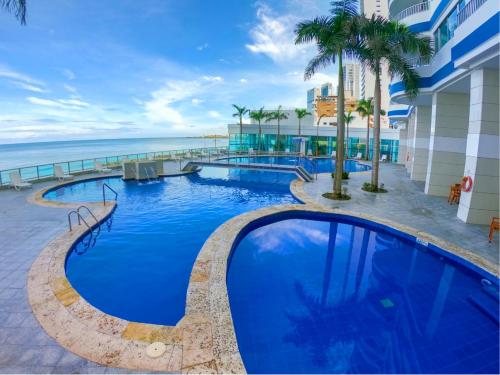 uma piscina de resort com vista para o oceano em Apartamentos Palmetto - Frente al Mar em Cartagena das Índias