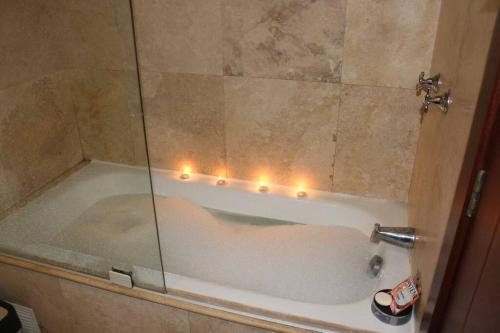 a bathroom with a tub with lights in it at Hermosa Suite, siéntete en casa! in Quito