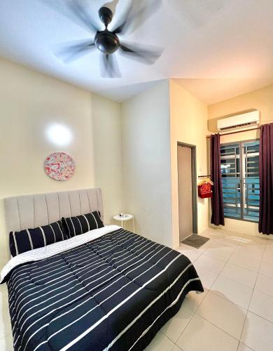 um quarto com uma ventoinha de tecto e uma cama em Homestay Akasia 12 em Seri Iskandar