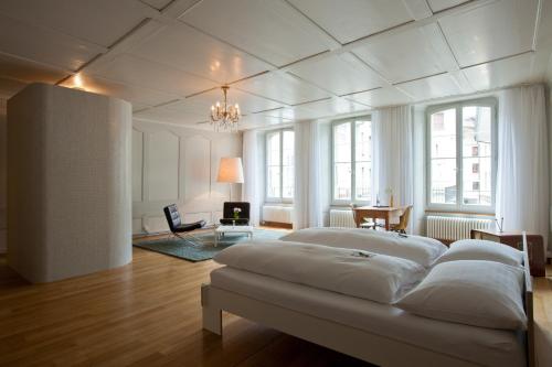 a large white bedroom with a bed in a room at Hotel Restaurant Schwert Thun in Thun