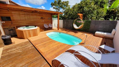 a patio with a hot tub on a wooden deck at Casa 4 quartos com Piscina e Jacuzzi em Jurerê in Florianópolis