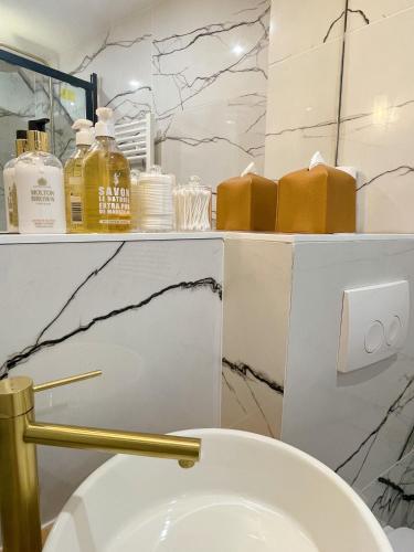 La salle de bains est pourvue de toilettes avec une poignée d'or. dans l'établissement Cocoon Gallery Paris, à Paris