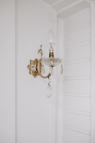 a chandelier is hanging on a white wall at Jacks Garden Cottage at Poets Lodge in Daylesford