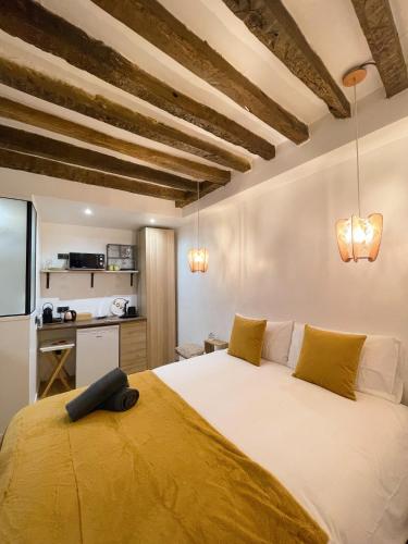 - une chambre dotée d'un grand lit avec des draps jaunes dans l'établissement Cocoon Gallery Paris, à Paris