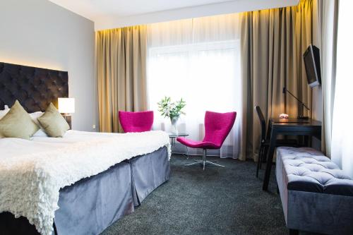 una camera d'albergo con letto, tavolo e sedie di Nova Park Conference a Knivsta