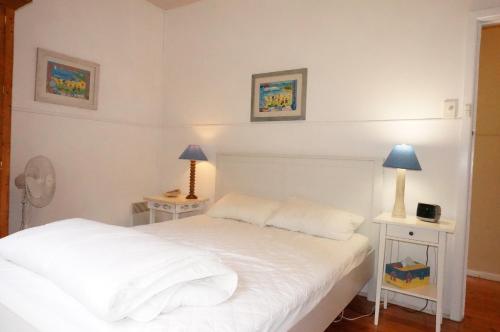 a bedroom with two white beds and two lamps at Dinghys Rest in Queenscliff