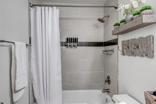 a bathroom with a shower with a white shower curtain at Chic Poolside Oasis - Karaoke - BBQ - Games in Phoenix