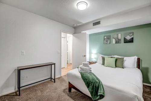 a bedroom with a white bed and a green wall at Chic Poolside Oasis - Karaoke - BBQ - Games in Phoenix