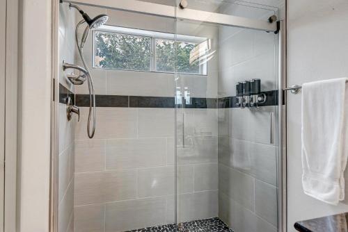 a bathroom with a shower with a glass door at Chic Poolside Oasis - Karaoke - BBQ - Games in Phoenix