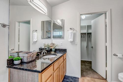 a bathroom with a sink and a mirror at Chic Poolside Oasis - Karaoke - BBQ - Games in Phoenix