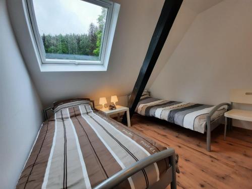 2 Betten in einem Zimmer mit Fenster in der Unterkunft Cozy holiday home in a unique location in Winterberg in Winterberg