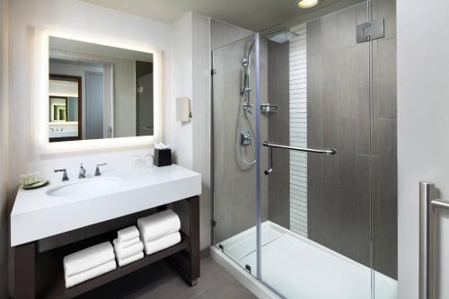 a bathroom with a sink and a glass shower at The Westin Austin Downtown in Austin
