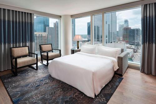 - une chambre avec un grand lit blanc et de grandes fenêtres dans l'établissement The Westin Austin Downtown, à Austin