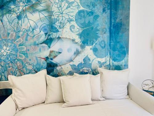 a couch with pillows in front of a blue and white wall at Salvador Cuyas "Apartamento el Mar" in Las Palmas de Gran Canaria