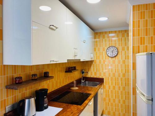 a kitchen with a sink and a clock on the wall at Salvador Cuyas "Apartamento el Mar" in Las Palmas de Gran Canaria