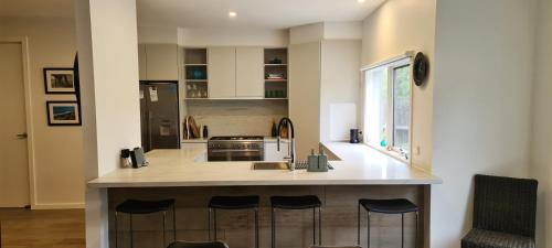 a kitchen with a island with a sink and a stove at Sand Dunes in Point Lonsdale