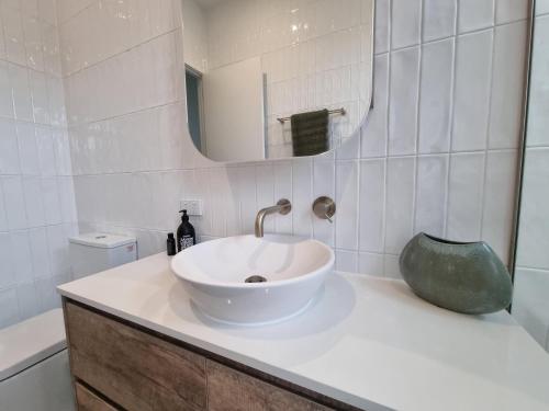 a bathroom with a white sink and a mirror at Sand Dunes in Point Lonsdale