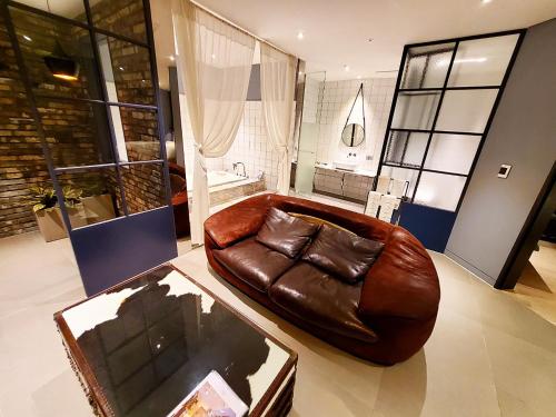 a brown leather couch sitting in a living room at Le Stendal Hotel in Daejeon