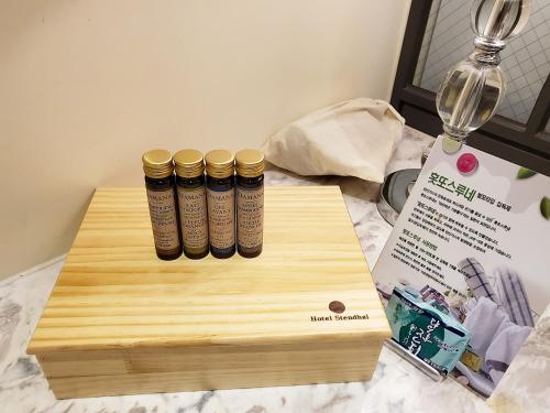 three gold bangles on a wooden cutting board next to a wine glass at Le Stendal Hotel in Daejeon