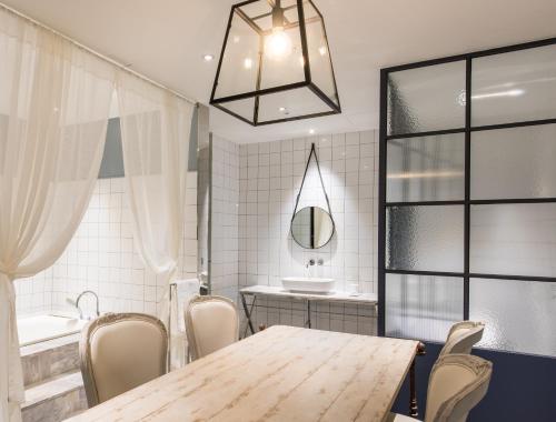 a dining room with a table and chairs and a tub at Le Stendal Hotel in Daejeon