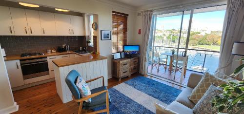 a living room with a kitchen and a large window at Harbourfront Bliss - 2 bedrooms, parking, balcony in Sydney