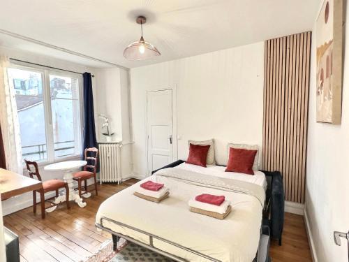 a bedroom with two beds with red pillows on them at Cosy Studio Père-lachaise-Pelleport in Paris