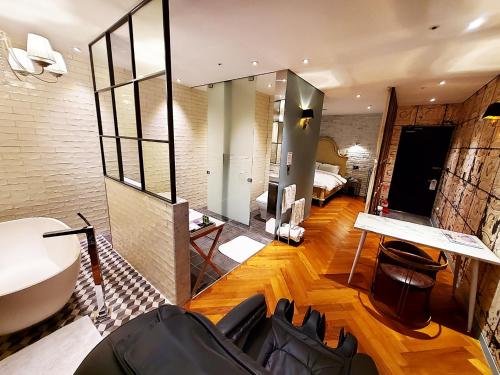 Le Stendal Hotel في دايجون: غرفة معيشة مع حوض وغرفة نوم