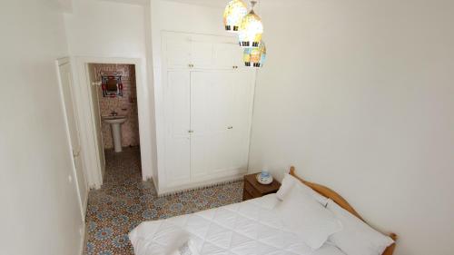 a white room with a bed and a sink at zina surf house in Oualidia