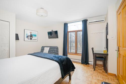 a bedroom with a bed and a desk and a window at Accueil Chez Francois in Montréal