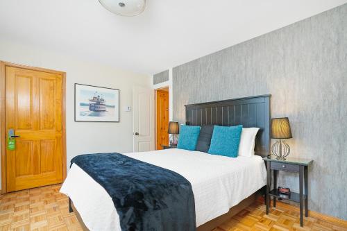 a bedroom with a large bed with blue pillows at Accueil Chez Francois in Montréal