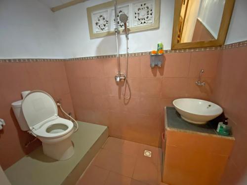 La salle de bains est pourvue de toilettes et d'un lavabo. dans l'établissement Ganesh Room, à Ubud