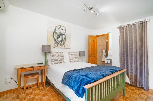 a bedroom with a bed and a nightstand and a table at Accueil Chez Francois in Montréal